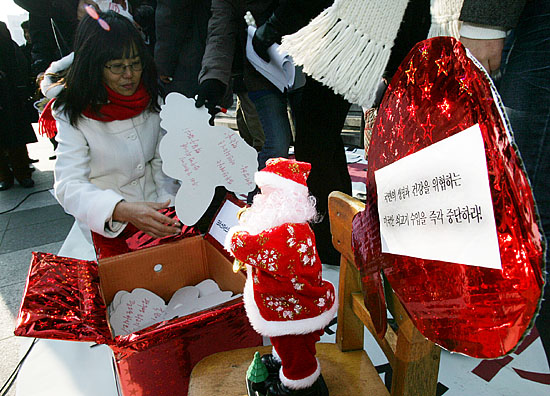 노무현 대통령에게 보내는 크리스마스 선물상자에 항의서한을 담고 있다. [사진-통일뉴스 김주영 기자]