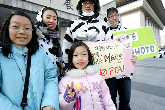 '광우병 소'로 분장한 한의대생들이 길을 지나던 아이들과 기념촬영을 하고 있다. 기념촬영한 사진은 http://club.cyworld.com/nofta-hani 에서 볼 수 있다. [사진-통일뉴스 김주영 기자]