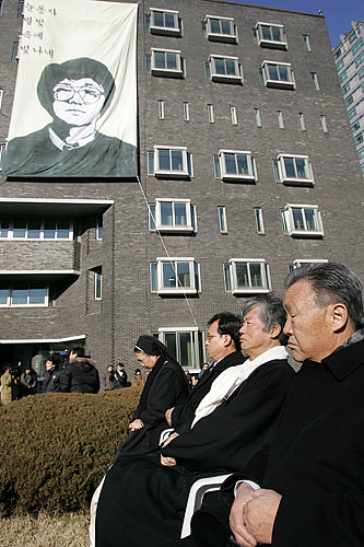 대형 초상이 대공분실 건물에 낼걸린 가운데 열사의 부친 박정기씨가 침통한 표정으로 생각에 잠겼다. [사진-통일뉴스 김주영 기자]