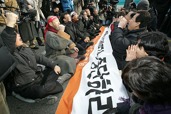 기자회견을 마친 각계 대표들이 신라호텔 입구에서 단식연좌농성에 들어간 민주노동당 국회의원들을 방문, 함께 함성을 외치고 있다. [사진-통일뉴스 김주영 기자]