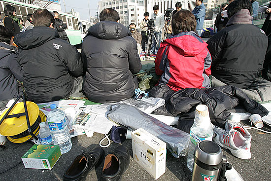 협상장 앞에서 단식 노숙농성 나흘째를 맞은 의원들 뒤로 물과, 신발, 책 등이 어지럽게 놓여 있다. [사진-통일뉴스 김주영 기자]