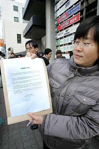 시사저널 기자가 직장폐쇄 공고문을 들고 있다. 금창태 사장은 직장폐쇄 2시간전인 11시경 전화로 노조 지도부에 직장폐쇄를 통보했다. [사진-통일뉴스 김주영 기자]