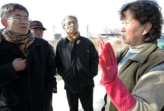군산기지 확충으로 협의매수가 진행되고 있는 하제마을 주민이 유영재 평통사 사무처장에게 전투기 소음과 협의매수가 헐값으로 진행된다며 하소연하고 있다. [사진-통일뉴스 김주영 기자]