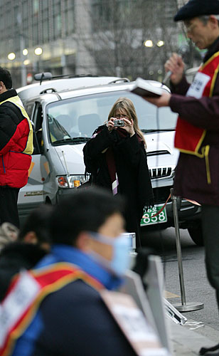 길을 지나던 외국인이 결의대회 광경을 카메라에 담고 있다. [사진-통일뉴스 김주영 기자]