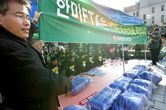 농성장 천막에'한미FTA'의 부당성을 시민들에게 알리는 플랜카드를 걸고 있다.[사진-통일뉴스 김주영 기자]