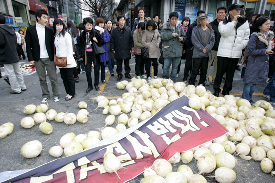 길을 지나던 시민들이 도심 한복판 널브러진 무를 바라보고 있다. [사진-통일뉴스 김주영 기자]