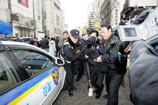 기습선전전을 진행하던 농민 한명이 연행되고 있다. [사진-통일뉴스 김주영 기자]