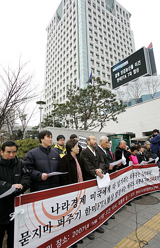 같은날 오전 10시 서울 종로구 도렴동 외교부청사 앞에서 '한미FTA저지범국본'이 외교통상부 규탄 기자회견을 연 가운데 기자회견 참가자들 뒤로 외교부청사 뉴스 전광판에 한미FTA협상에 대한 기사가 흐르고 있다. [사진-통일뉴스 김주영 기자]