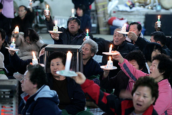13일 오후 6시30분 대추리 농협창고에서 896번째 주민촛불문화제가 열렸다. 여느 때와 같이 촛불을 높이 치켜들었으나 주민들의 표정은 어둡기만 하다. [사진-통일뉴스 김주영 기자]