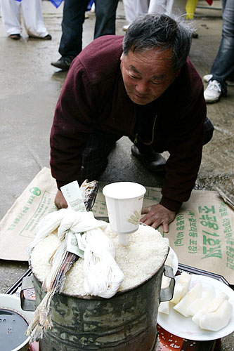 고사 쌀에 절을 하며 집안의 안녕을 기원하는 이민강 할아버지.[사진-통일뉴스 김주영 기자]