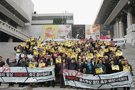 20여분간의 약식 행진을 마친 각계 인사 200여명은 세종문화회관 앞에서 행진을 마무리 했다. 갑자기 내린 눈 속에서 구호를 외치고 있는 참가자들. [사진-통일뉴스 김주영 기자]