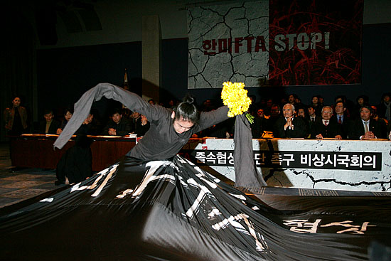 한편, 이날 오전 11시 프레스센터 20층 국제회의장에서 진행된 '한미FTA저지 비상시국선언'에서 문화연대가 '죽음의 협상 한미FTA'검은천을 뚫고 나오는 퍼포먼스를 선보였다. [사진-통일뉴스 김주영 기자]