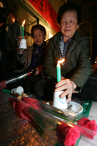 높이 치켜든 마지막 촛불을 내려놓은 주민들이 초를 끄지 못한 채 시선을 떼지 못하고 있다.[사진-통일뉴스 김주영 기자]