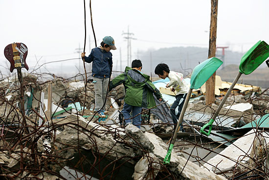 대추분교가 철거된 잔해 위에서 놀고 있는 마을 아이들. 위험해 보이지만 이렇게 마을을 마음껏 누비는 것도 얼마 남지 않았다. [사진-통일뉴스 김주영 기자]