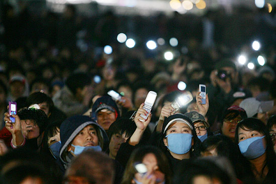 정리집회 도중 사회자의 ARS후원요청에 핸드폰을 꺼내는 참가자들. 날이 어두워지자 이들이 꺼내든 핸드폰 불빛이 집회장소를 밝히고 있다. [사진-통일뉴스 김주영 기자]