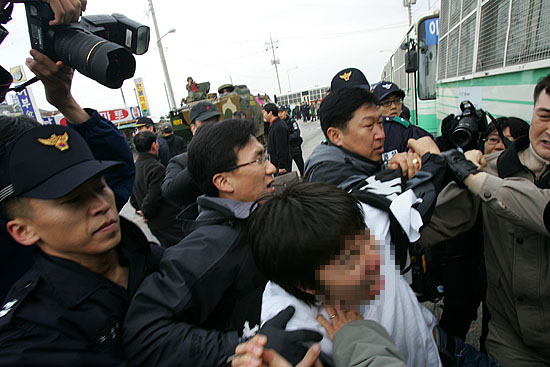 육지로 올라온 수륙장갑차에 항의하던 시위대가 연행됐다. [사진-통일뉴스 김주영 기자]