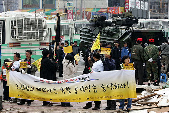 참가자들이 이동하고 있는 미 해병대 장갑차를 향해 피켓을 들어 보이고 있다.[사진-통일뉴스 김주영 기자]