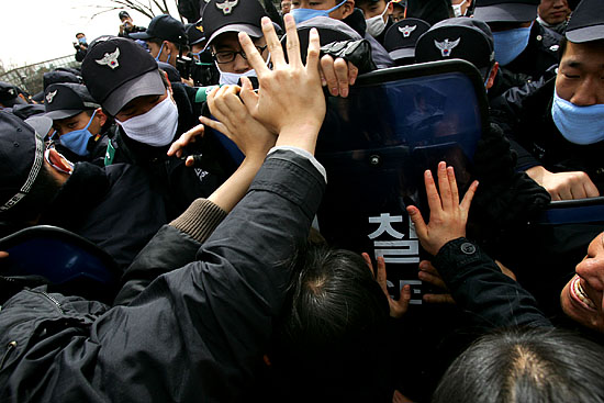 협상장 정문 앞에서 기자회견을 진행하려던 참가자들과 경찰이 몸싸움을 벌이고 있다. [사진-통일뉴스 김주영 기자]