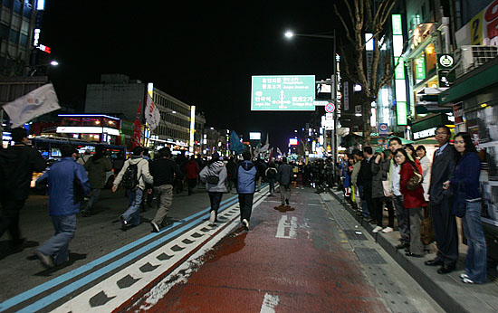 종각을 지나 종로3가 방면 갑자기 도로를 점거하고 나타난 시위대에 시민들이 시선을 고정시키고 있다. [사진-통일뉴스 김주영 기자]