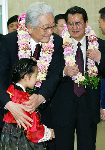 장웅 국제태권도연맹(왼쪽) 총재가 화동과 포옹하고 있다. 오른쪽은 황봉영 조선태권도위원회 위원장. [사진-통일뉴스 김주영 기자]