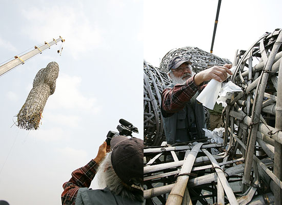 문무인상이 옮겨지는 모습을 촬영하는 문정현 신부(왼쪽). 문 신부가 문무인상에 소지를 묶고 있다.(오른쪽)[사진-통일뉴스 김주영 기자]