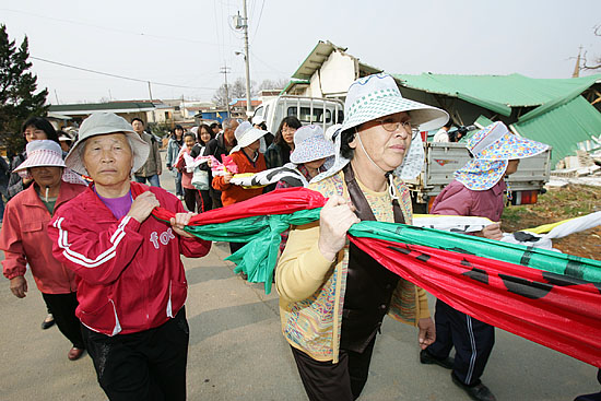 부서진 빈집을 지나 평화공원을 향하는 주민들. [사진-통일뉴스 김주영 기자]