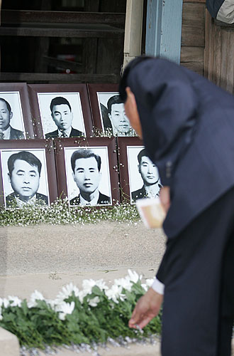 사형장 앞에 마련된 고인들의 영정사진 앞으로 헌화가 이어졌다. [사진-통일뉴스 김주영 기자]