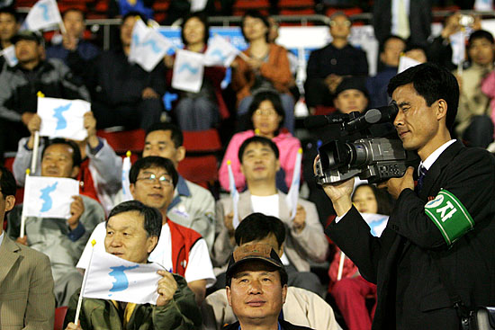 축구대회 장면과 응원하는 남측 관중을 취재하는 북측 취재단.[사진-통일뉴스 김주영 기자]