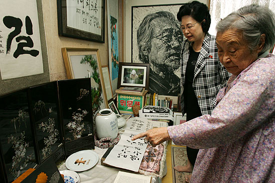 조대위 홍선옥 위원장에게 문익환 목사의 생전 유품들을 설명하는 박용길 장로(오른쪽). [사진-통일뉴스 김주영 기자]