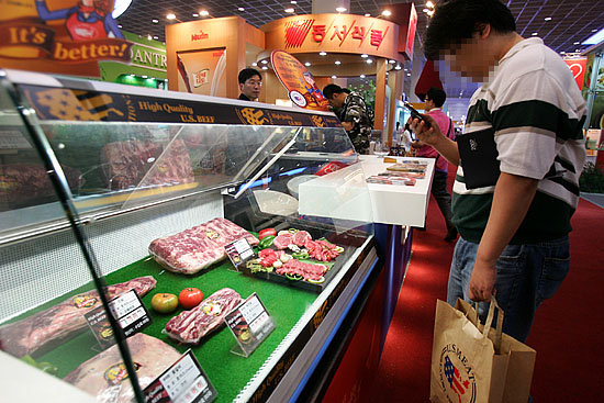 한편, '2007한국국제유통산업전'이 26일까지 서울 삼성동 코엑스몰에서 진행되는 가운데 한  관람객이 '미국육류수출협회'부스에 부위별로 진열된 미국산 쇠고기를 관람하고 있다. [사진-통일뉴스 김주영 기자]