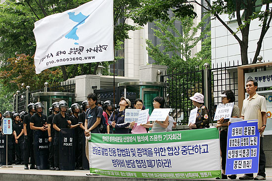 면담을 기다리는 기자회견 참가자들이 외교통상부 앞을 지나는 차량을 향해 방위비분담금 산정방식 변경 협의을 반대하는 현수막을 들고 있다. [사진-통일뉴스 김주영 기자]