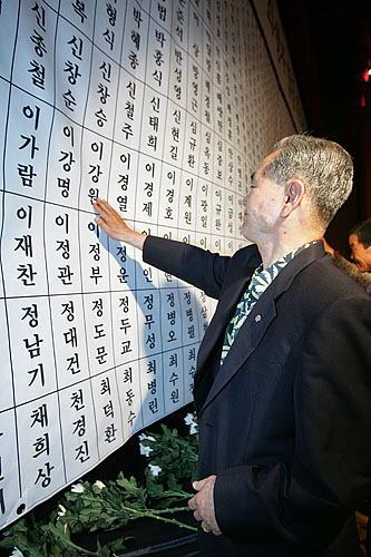 헌화를 마친 유가족이 헌화대를 떠나지 못하고 아들의 이름을 어루만지고 있다. [사진-통일뉴스 김주영 기자]