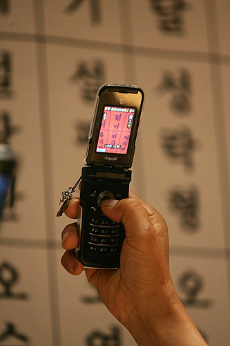 헌화를 마친 유가족들이 헌화대를 떠나지 못하고 아들의 이름을 휴대폰 카메라에 담고 있다. [사진-통일뉴스 김주영 기자]