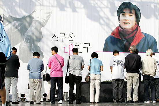 추모제 마지막 순서로 헌화 순서가 이어졌다. 헌화를 마치고 열사 앞에 묵념하는 추모객들.[사진-통일뉴스 김주영 기자]