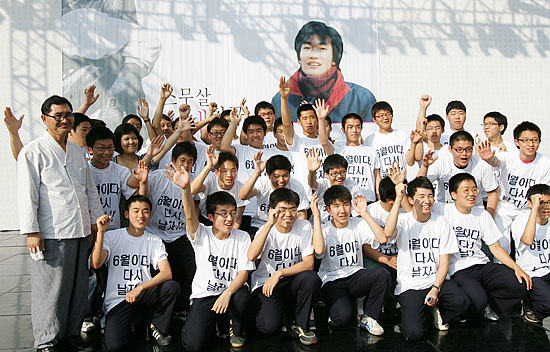 헌화를 마치고 기념촬영을 하는 광주 진흥고 후배들 뒤로 열사가 밝게 웃고 있다. [사진-통일뉴스 김주영 기자]