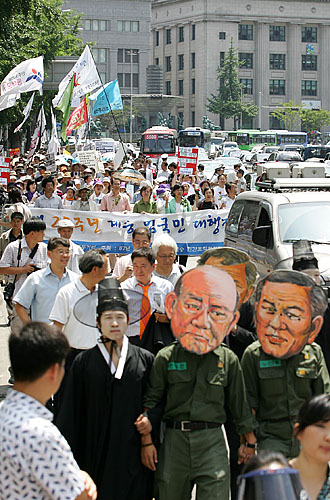 '저승사자에게 끌려가는 전두환,노태우'. 행렬 선두에는 군부독재시절의 상징인 전두환,노태우 전 대통령이 저승사자에게 끌려가는 퍼포먼스가 진행되고 있다. [사진-통일뉴스 김주영 기자]