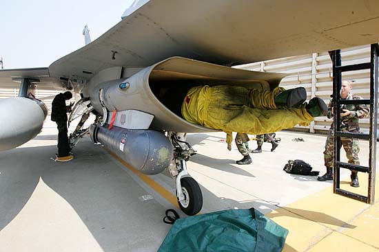 엔진점검을 위해 F16전투기 속으로 들어가고 있는 미군병사. [사진-통일뉴스 김주영 기자]