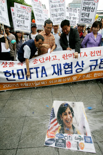 기자회견을 마치고 미측 대표인 웬디 커틀러 수석대표의 사진에 '한미FTA무효 물폭탄'을 던지는 참가자들. [사진-통일뉴스 김주영 기자]