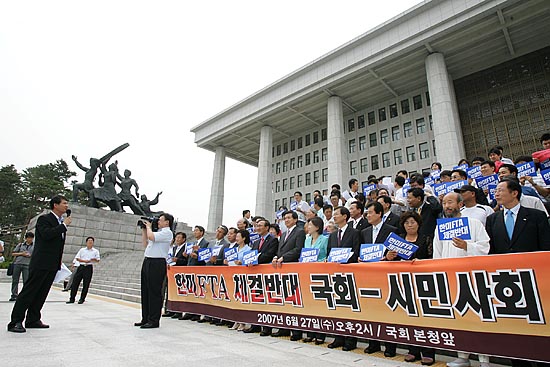 국회의원과 시민사회단체 대표들이 27일 오후 2시 국회 본청 앞에서 '국회 비준 거부에 나설 것'밝혔다. 사진은 시국선언 사회를 보고 있는 임종인 무소속 의원과 참가자들. [사진-통일뉴스 김주영 기자]