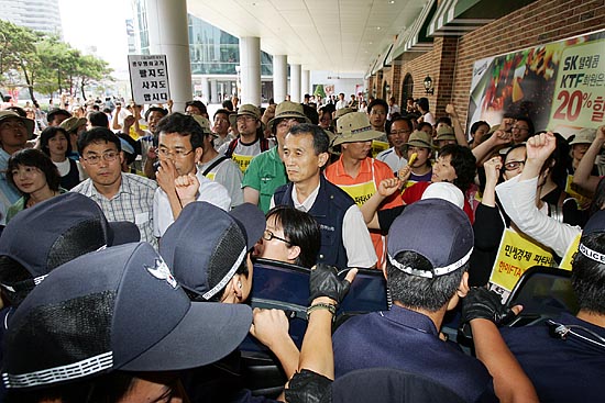 광우병 국민감시단과 범국본 소속 회원들이 미국산 쇠고기가 시판되고 있는 수입육 코너로 들어가기 위해 경찰과 대치를 벌이고 있다. [사진-통일뉴스 김주영 기자]