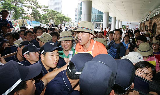 기자회견을 마친 참가자들이 롯데마트의 봉쇄된 출입구로 들어가기 위해 경찰과 실랑이를 벌이고 있다.[사진-통일뉴스 김주영 기자]
