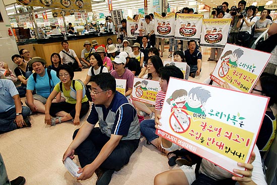 이날 오전 11시 20분경 경찰의 봉쇄를 따돌리고 롯데마트 서울역점 매장 안으로 들어선 범국본 참가자들과 국민감시단이 매장을 점거한 채 미국산 쇠고기 시판을 중단과 지점장과의 면담을 요구하고 있다. [사진-통일뉴스 김주영 기자]