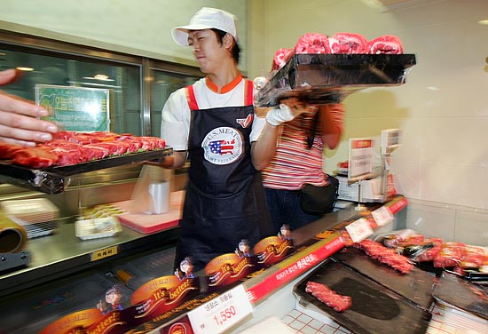 미국산 쇠고기를 판매하는 별도의 코너에서 근무하는 직원이 미육류수출협회 로고가 세겨진 앞치마를 착용한 채 미국산 쇠고기를 저장고 안으로 옮기고 있다. [사진-통일뉴스 김주영 기자]