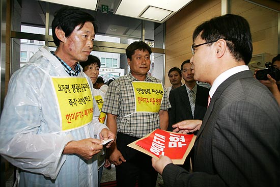 범국본 기자회견 대표단의 항의서한을 거부하던 박근혜 선거 캠프 관계자가 빌딩 입구에서 항의서한을 받고 있다. [사진-통일뉴스 김주영 기자]