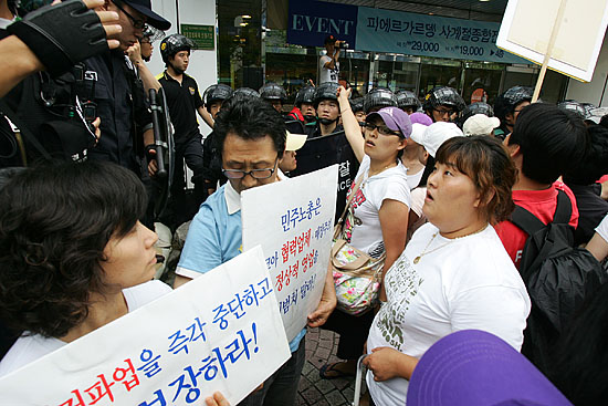 뉴코아아울렛 매장 내 입주점포 사장들이 매장내로 진입하려는 이랜드 조합원들에게 