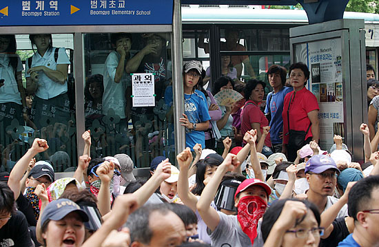 뉴코아 아울렛 평촌점 앞을 지나는 시민들이 이랜드 노조원들의 집회를 지켜보고 있다. [사진-통일뉴스 김주영 기자]