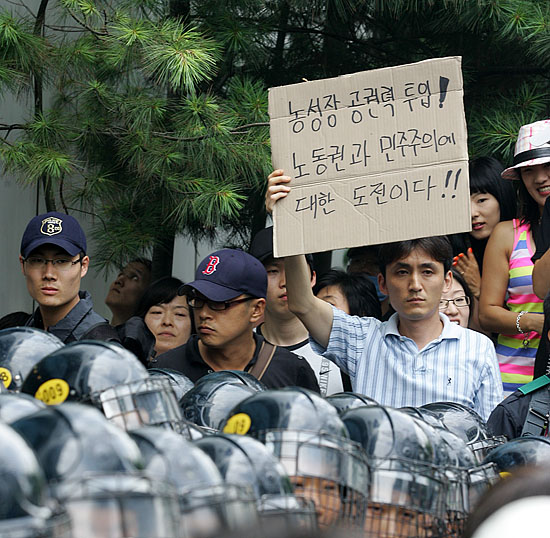 이날 뉴코아 아울렛 평촌점에 대한 이랜드 노조와 민주노총의 점거계획을 미리 파악한 경찰은 조합원들의 집결에 앞서 매장의 영업을 중단시키고 모든 입구를 봉쇄했다. 경찰의 강제진압에 항의하는 피켓을 든 노조원. [사진-통일뉴스 김주영 기자]