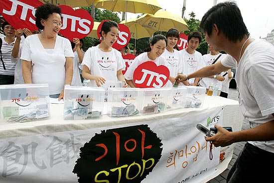 발길을 멈추고 모금에 동참하는 시민. JTS는 1차로 7월 18일 밀가루 500톤을(약 3억 1천 만원)을 2006년 수해지역인 평안남도 양덕군, 신양군, 성천군에 보낸 바 있다. [사진-통일뉴스 김주영 기자]