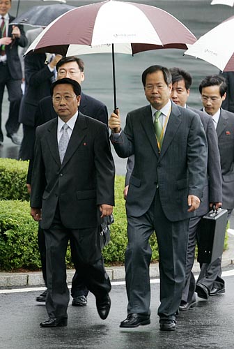 '나란히 한 우산 쓴 남북 수석대표'. 남북 수석대표인 김명섭 유엔주재 북한대표부 공사(왼쪽)와 남측천영우 평화교섭본부장이 나란히 한 우산을 쓰고 회담장인 '평화의 집'으로 향하고 있다. [인터넷사진공동취재단 김주영 기자]