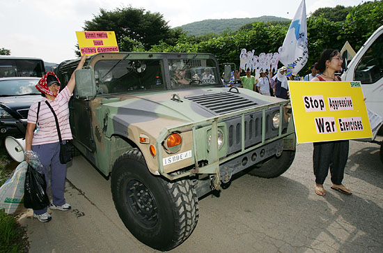 20일 오전 10시 경기도 성남 소재 청계산 중턱에 위치한 탱고 기지 앞에서 열린'을지포커스렌즈 연습(FUL) 강행 규탄 기자회견'을 마친 참가자들이 기지 안으로 들어가던 미군차량을 향해 UFL연습을 반대하는 피켓을 들고 항의하고 있다. [사진-통일뉴스 김주영 기자]